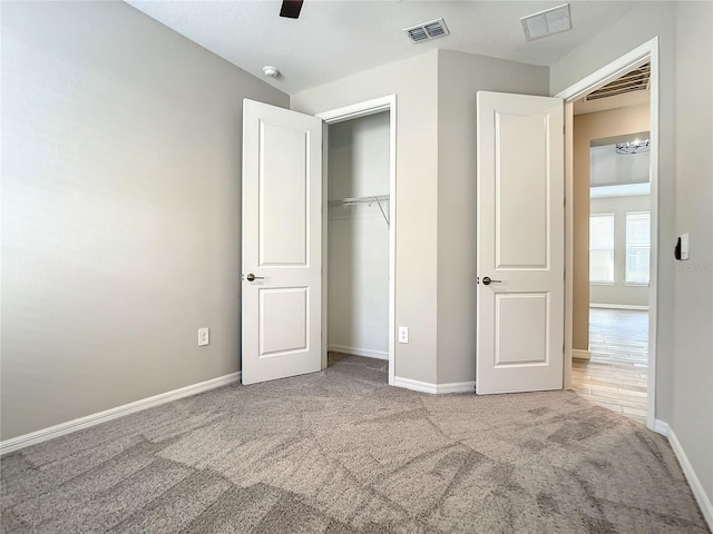 unfurnished bedroom with carpet floors, baseboards, a closet, and a ceiling fan