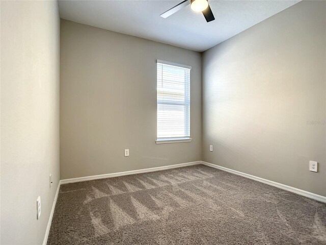 empty room with a ceiling fan, carpet floors, and baseboards