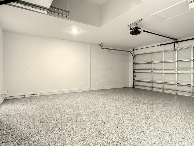 garage with a garage door opener and concrete block wall