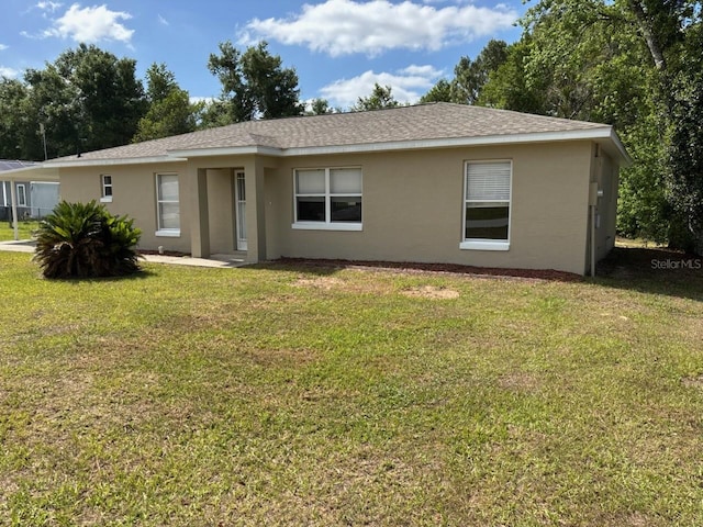 4046 E Bennett St, Inverness, FL 34453 - view of front of property featuring roof with shingles, a front yard, and stucco siding