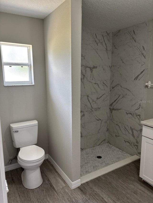 4046 E Bennett St, Inverness, FL 34453 - full bath featuring wood finished floors, a textured ceiling, a stall shower, and toilet