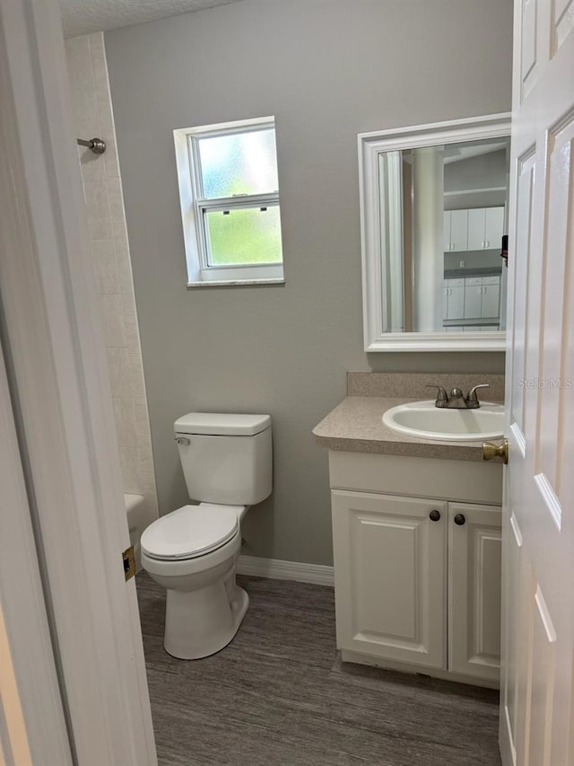 4046 E Bennett St, Inverness, FL 34453 - full bathroom with walk in shower, wood finished floors, vanity, baseboards, and toilet