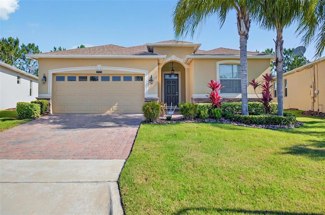 view of front of property featuring an attached garage, stucco siding, decorative driveway, and a front yard