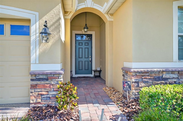 entrance to property featuring stone siding and stucco siding