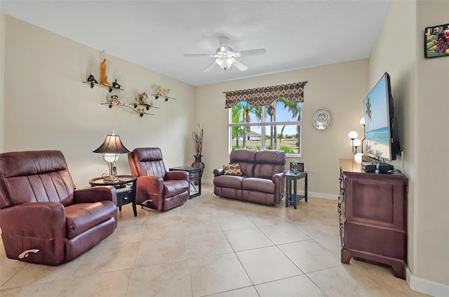 living room with ceiling fan, baseboards, and light tile patterned floors