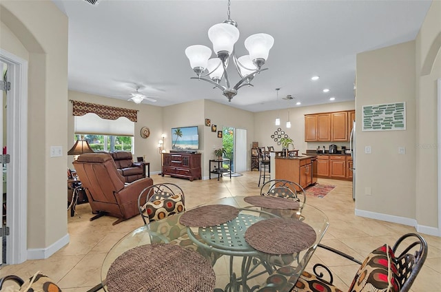 dining space with arched walkways, light tile patterned flooring, and ceiling fan with notable chandelier
