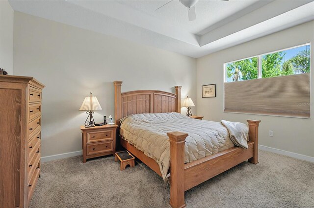bedroom featuring light colored carpet, baseboards, and ceiling fan