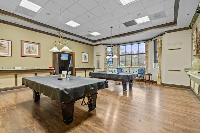 game room with a paneled ceiling, ornamental molding, pool table, and wood finished floors