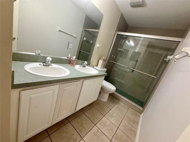 full bath featuring tile patterned flooring, toilet, a shower stall, and a textured ceiling