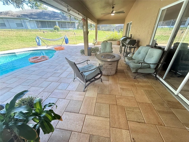 view of patio / terrace with a fire pit and a ceiling fan