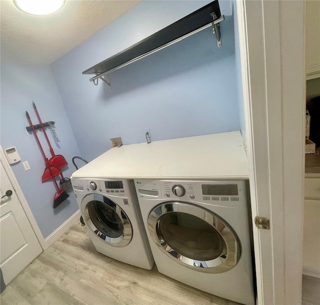 washroom with separate washer and dryer and light wood-style flooring