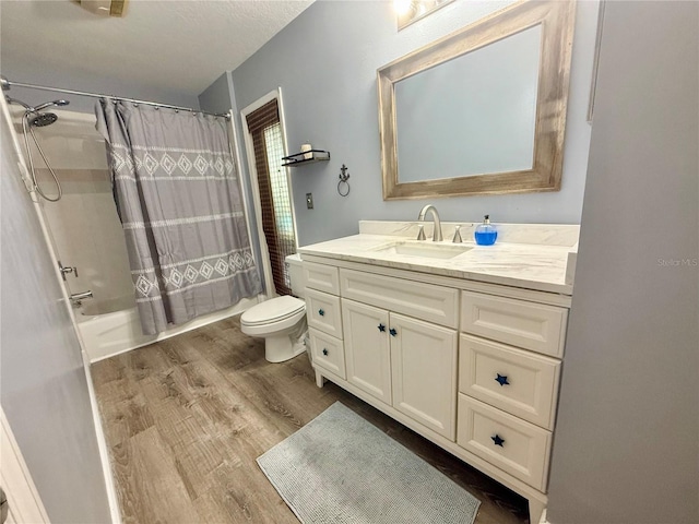 full bath featuring wood finished floors, toilet, vanity, and shower / bath combo with shower curtain