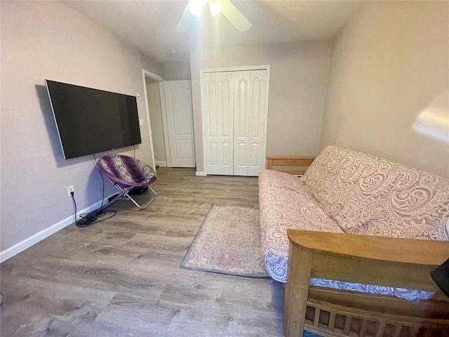 living room featuring wood finished floors, ceiling fan, and baseboards