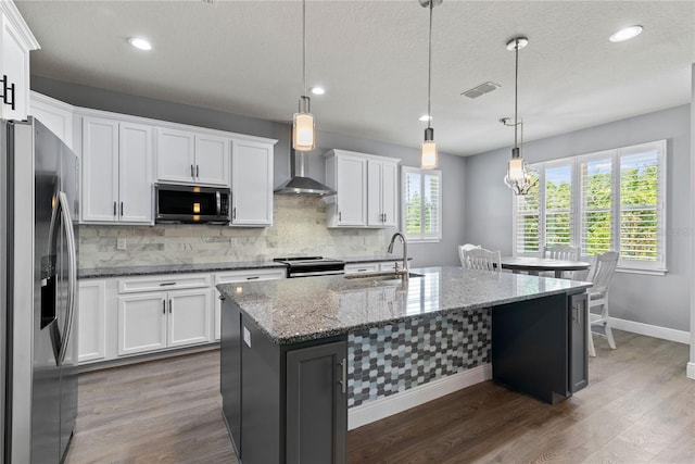 kitchen with decorative backsplash, visible vents, a sink, baseboards, and stainless steel appliances