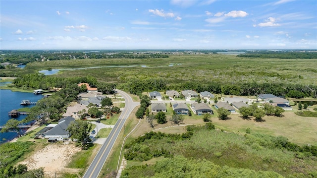 drone / aerial view with a water view, a view of trees, and a residential view