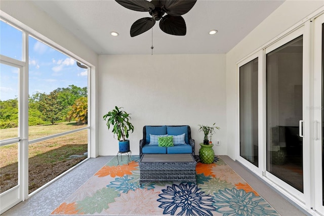 sunroom featuring ceiling fan and an outdoor living space