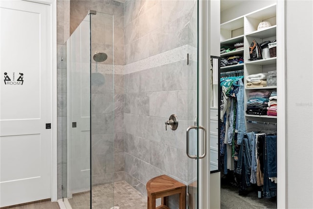 bathroom featuring a walk in closet and a stall shower