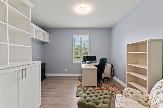 office area featuring baseboards, dark wood-style floors, and a textured ceiling