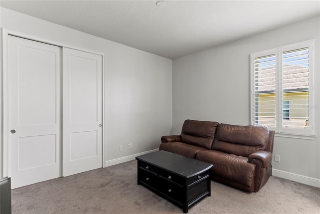 living room featuring baseboards and light colored carpet