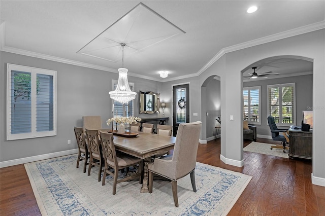 dining room with arched walkways, baseboards, ceiling fan with notable chandelier, and wood finished floors