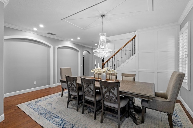 dining area featuring ornamental molding, wood finished floors, baseboards, recessed lighting, and a notable chandelier