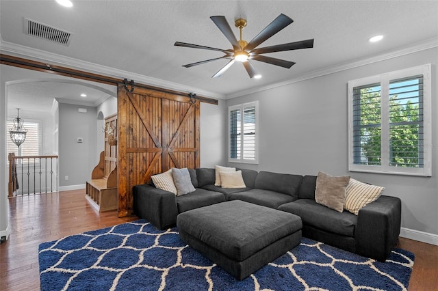 living room featuring visible vents, a ceiling fan, wood finished floors, and a healthy amount of sunlight