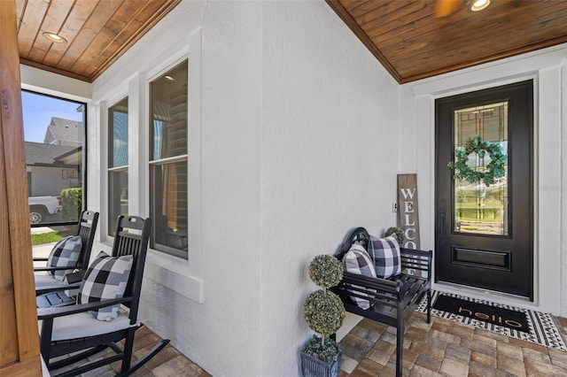 doorway to property with a porch and stucco siding
