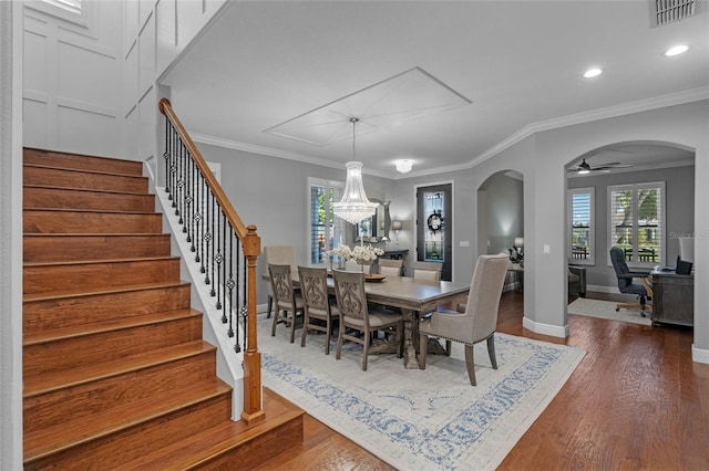 dining room featuring crown molding, arched walkways, dark wood-type flooring, and visible vents