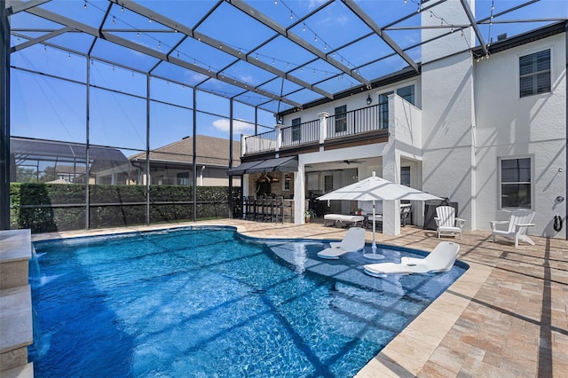 view of swimming pool featuring ceiling fan, a lanai, outdoor dry bar, a patio area, and a fenced in pool