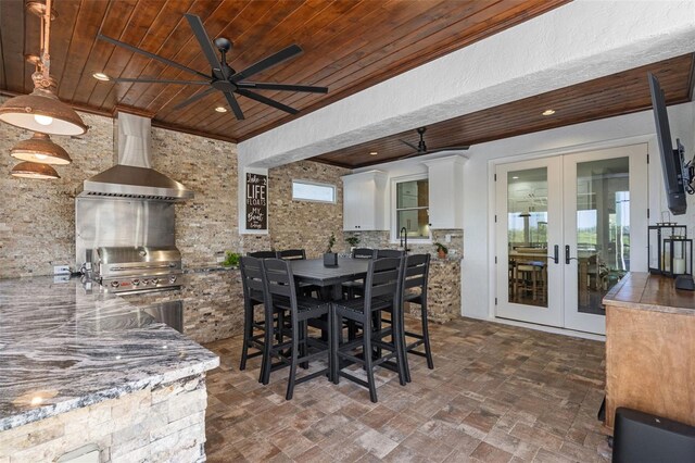 view of patio / terrace featuring outdoor dining space, exterior kitchen, ceiling fan, area for grilling, and french doors