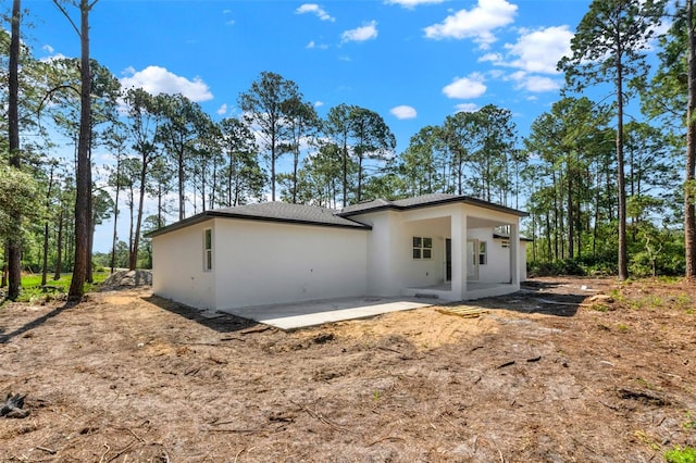 back of house with a patio and stucco siding