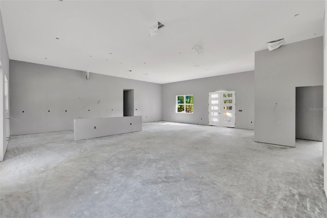 unfurnished living room featuring unfinished concrete flooring