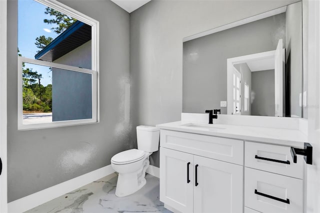 bathroom featuring baseboards, vanity, toilet, and marble finish floor