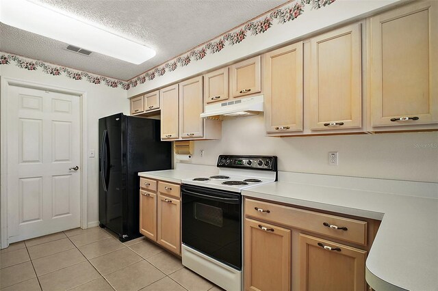 705 Grand Vista Trl, Leesburg, FL 34748 - kitchen featuring range with electric cooktop, a textured ceiling, light countertops, freestanding refrigerator, and under cabinet range hood