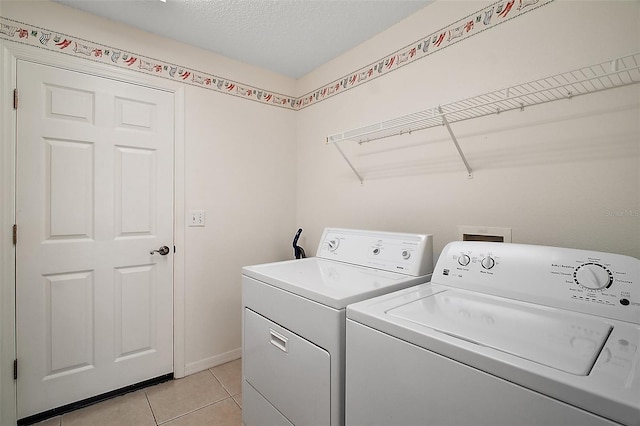 705 Grand Vista Trl, Leesburg, FL 34748 - laundry area featuring laundry area, a textured ceiling, light tile patterned floors, and separate washer and dryer