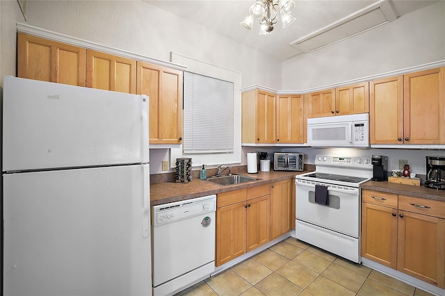 kitchen with a sink, dark countertops, white appliances, and light tile patterned flooring
