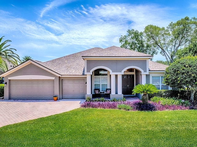 3775 Brantley Place Cir, Apopka, FL 32703 - view of front of house with a front lawn, a garage, stucco siding, driveway, and roof with shingles