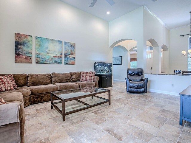 3775 Brantley Place Cir, Apopka, FL 32703 - living area featuring a towering ceiling, arched walkways, a ceiling fan, baseboards, and crown molding