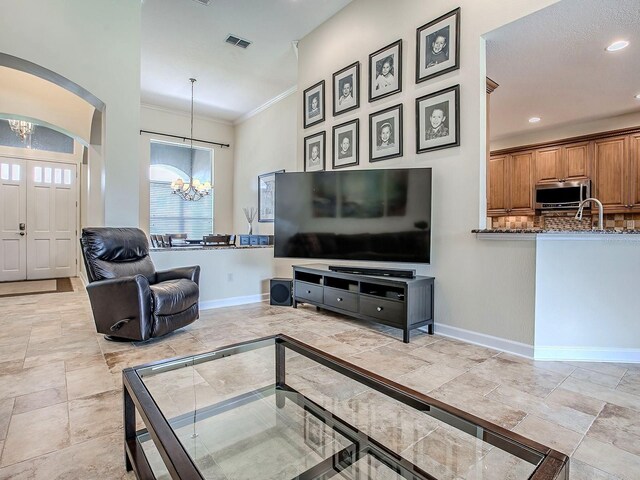 3775 Brantley Place Cir, Apopka, FL 32703 - living room featuring a chandelier, baseboards, crown molding, arched walkways, and recessed lighting