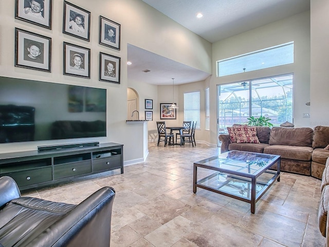3775 Brantley Place Cir, Apopka, FL 32703 - living area featuring baseboards, a towering ceiling, arched walkways, and recessed lighting