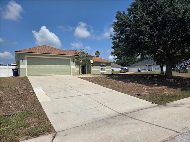 view of front of property featuring concrete driveway, an attached garage, and stucco siding