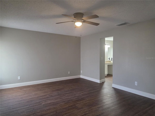 unfurnished room featuring a ceiling fan, dark wood-style flooring, baseboards, and a textured ceiling