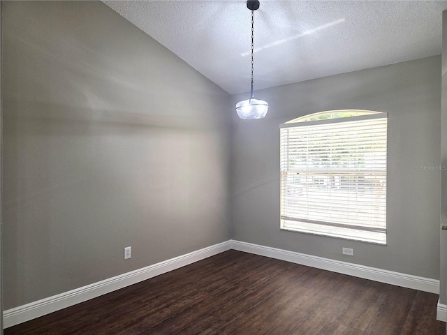 empty room with dark wood-style flooring, baseboards, a textured ceiling, and lofted ceiling