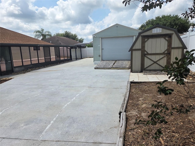 view of patio featuring a storage unit, an outbuilding, and fence