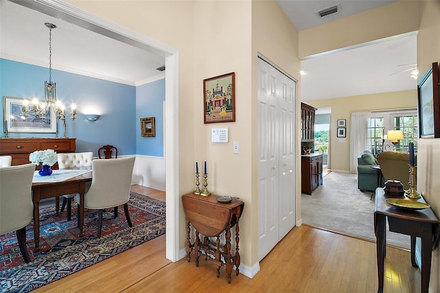 interior space with baseboards, light wood finished floors, and visible vents