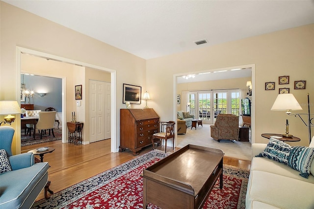 living area featuring visible vents, wood finished floors, and french doors