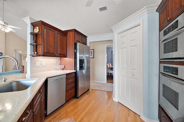 kitchen with backsplash, a ceiling fan, visible vents, appliances with stainless steel finishes, and a sink