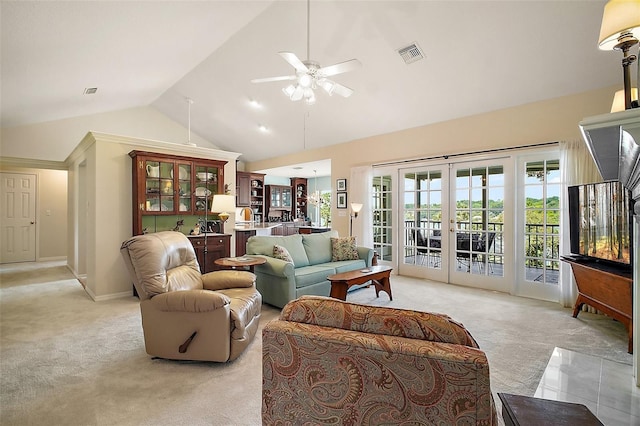 living room with light colored carpet, french doors, a ceiling fan, lofted ceiling, and visible vents