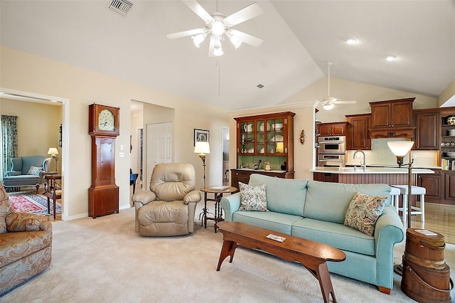 living area with visible vents, light carpet, baseboards, a ceiling fan, and vaulted ceiling