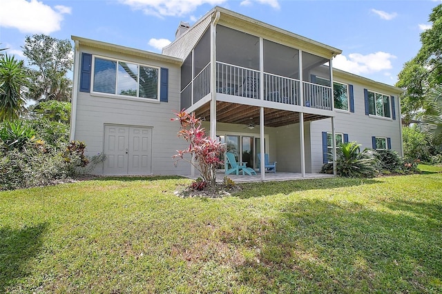 rear view of property featuring a yard, a patio, a ceiling fan, and a sunroom